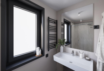 Baño moderno en la Stanzertal Cabin en Austriaparks Camping Arlberg, Austria, con ventana y espejo amplios.