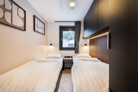 Moderne tweepersoonskamer met gezellige uitstraling in Stanzertal Cabin bij Austriaparks Camping Arlberg, Oostenrijk.