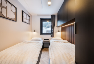 Moderne tweepersoonskamer met gezellige uitstraling in Stanzertal Cabin bij Austriaparks Camping Arlberg, Oostenrijk.
