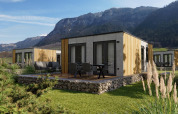 Cabane Stanzertal moderne à Austriaparks Camping Arlberg, Autriche, nichée parmi des montagnes verdoyantes.
