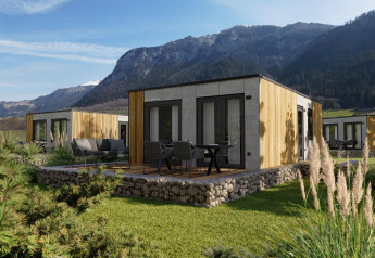 Cabane Stanzertal moderne à Austriaparks Camping Arlberg, Autriche, nichée parmi des montagnes verdoyantes.