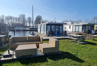 Casa flotante 'Aqua Dolce' en Welcome In - Friesland, Países Bajos, con terraza y vistas al agua.