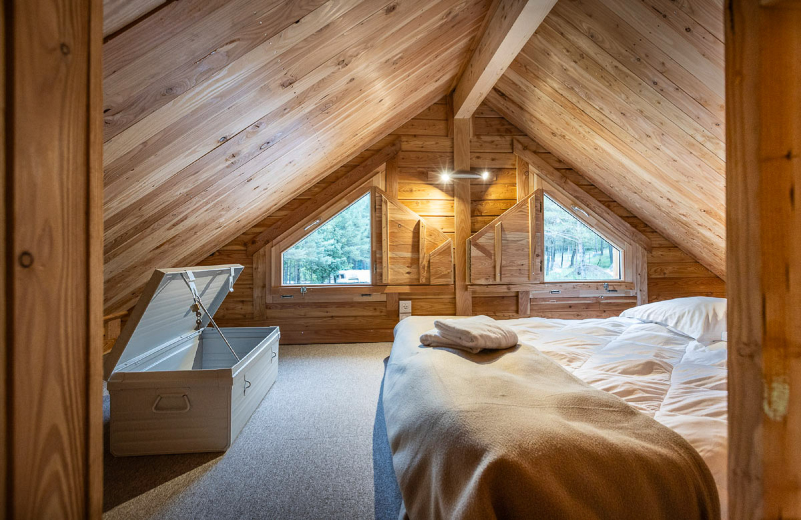 Zolderkamer in Chalet Montana Vista bij Huttopia Champagny en Vanoise, Frankrijk, met houten interieur.