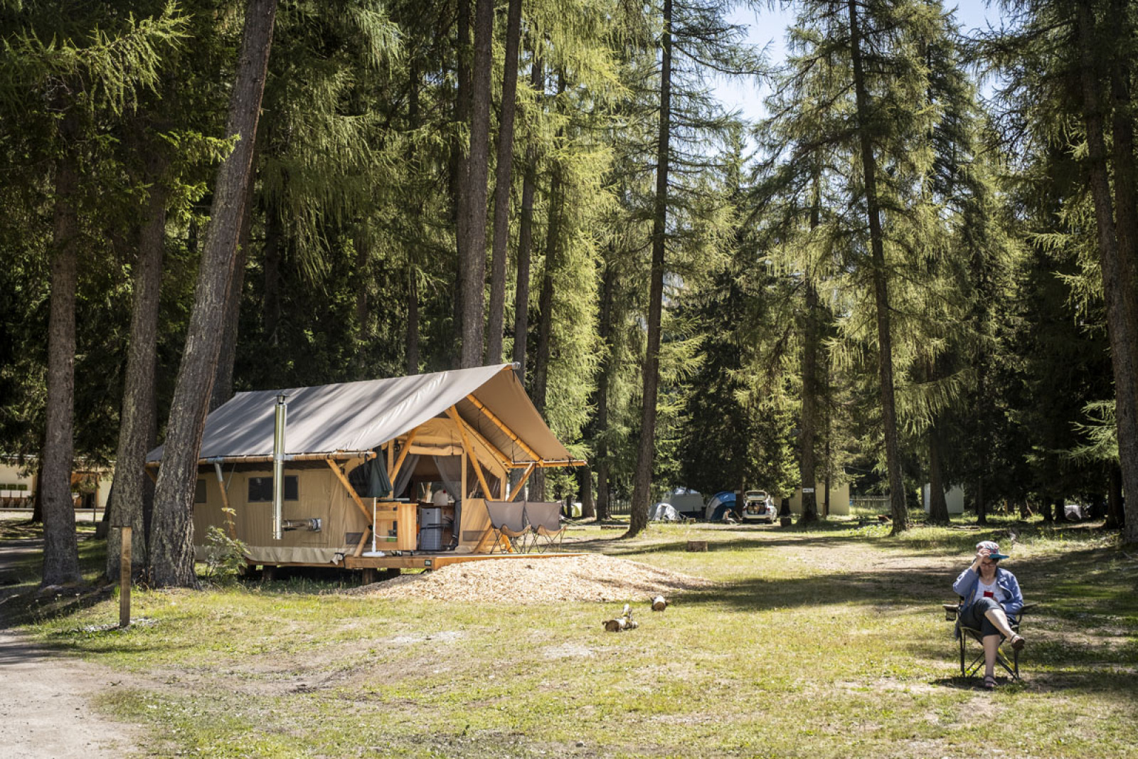 Safari tent Tent Canadienne bij Huttopia Champagny en Vanoise in Frankrijk, tussen hoge dennenbomen.