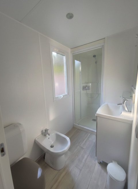 Modernes, helles Badezimmer im Mobile Home «Royal» im Centro Vacanze San Marino mit Dusche und Bidet.