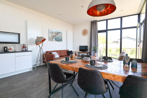Moderne woon- en eetkamer in Cube Exclusive Plus tiny house bij EuroParcs Bad Meersee, Nederland, lichte inrichting.