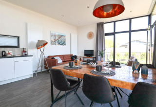 Moderne woon- en eetkamer in Cube Exclusive Plus tiny house bij EuroParcs Bad Meersee, Nederland, lichte inrichting.