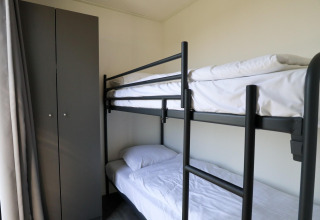 Moderne stapelbed en kast in een kleine kamer van de Cube Exclusive Plus, EuroParcs Bad Meersee, Nederland.