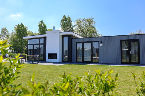 Cube Exclusive Plus tiny house bij EuroParcs Bad Meersee, Nederland, met ruime tuin en zithoek buiten.