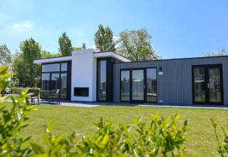 Modern Cube Exclusive Plus tiny house at EuroParcs Bad Meersee, Netherlands, with garden and patio area.
