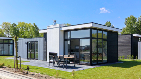 Modern Cube Exclusive Plus tiny house at EuroParcs Bad Meersee, Netherlands, with large windows and outdoor patio.