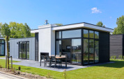 Moderne Cube Exclusive Plus tiny house bij EuroParcs Bad Meersee, Nederland, met grote ramen en terras.