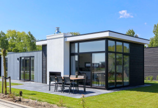 Moderne Cube Exclusive Plus tiny house bij EuroParcs Bad Meersee, Nederland, met grote ramen en terras.