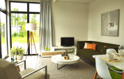 Moderne zithoek in de Cube tiny house bij EuroParcs Bad Meersee, Nederland, met grote ramen en decor.