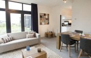 Moderne leef- en eetruimte in de tiny house Cube La Mer 4 bij EuroParcs Bad Meersee, Nederland, met lichtinval.