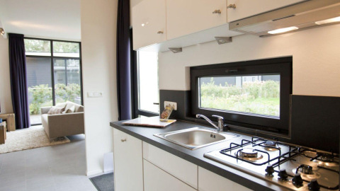 Modern compacte keuken en woonkamer in Cube tiny house La Mer 4 bij EuroParcs Bad Meersee, Nederland.