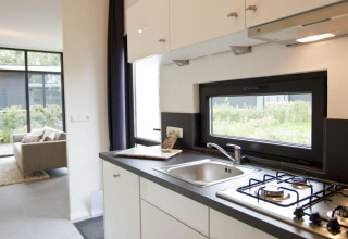 Modern compacte keuken en woonkamer in Cube tiny house La Mer 4 bij EuroParcs Bad Meersee, Nederland.