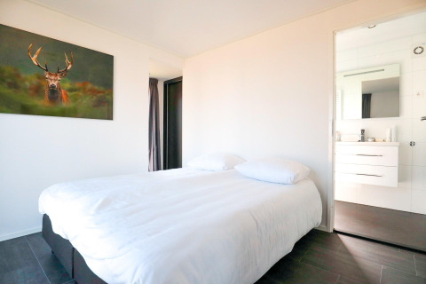 Slaapkamer in een Cube Exclusive 4 tiny house bij EuroParcs Bad Meersee, Nederland, met hertenfoto.
