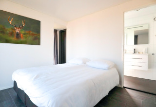 Slaapkamer in een Cube Exclusive 4 tiny house bij EuroParcs Bad Meersee, Nederland, met hertenfoto.