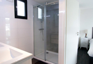 Moderne badkamer met douche en zicht op slaapkamer in Cube Exclusive 4 tiny house bij EuroParcs Bad Meersee.