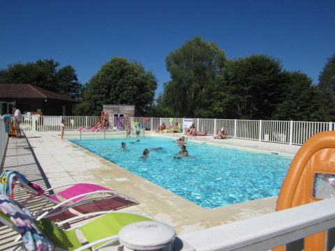 Piscina all'aperto al campeggio Seasonova Lac de Bournazel, ospiti che si rilassano in Nouvelle-Aquitaine.