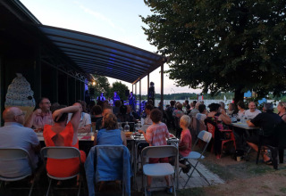Evening outdoor dining and live music at Campsite Seasonova Lac de Bournazel holiday park in Nouvelle-Aquitaine, France.
