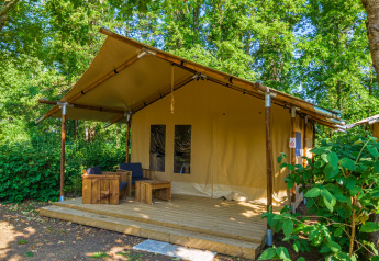 Tienda safari llamada Slow lodge con 2 dormitorios, muebles de madera y terraza en entorno boscoso.
