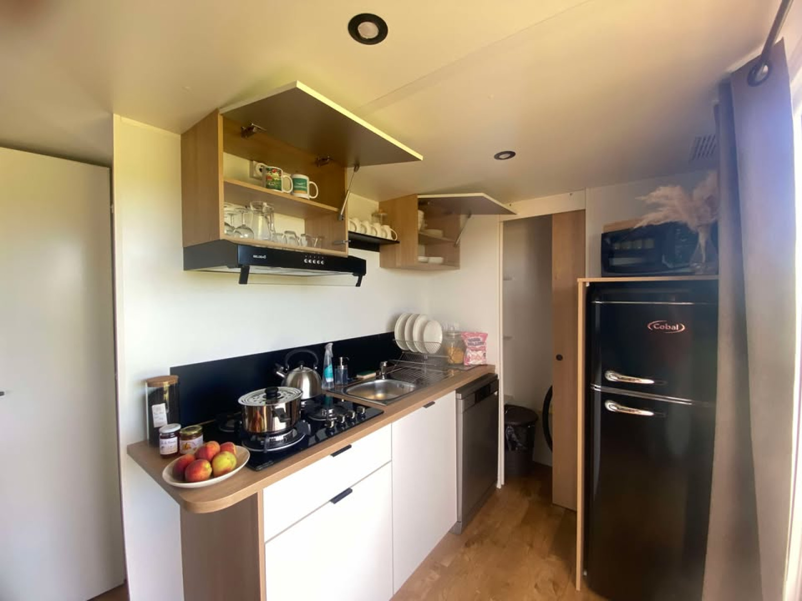 Moderne keuken in een cottage met twee slaapkamers op Camping Seasonova Lac de Bournazel, Frankrijk.