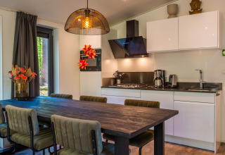 Moderne keuken en eetruimte in Zandborg Lodge van vakantiepark De Wiltzangh, Nederland, met trendy inrichting.