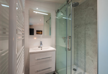 Bagno moderno alla Zandborg Lodge, De Wiltzangh, Paesi Bassi, con doccia in vetro e lavabo.