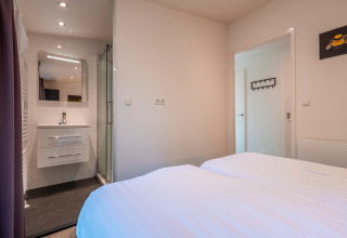 Værelse på Zandborg Lodge ved De Wiltzangh med dobbeltseng, privat badeværelse og moderne indretning.