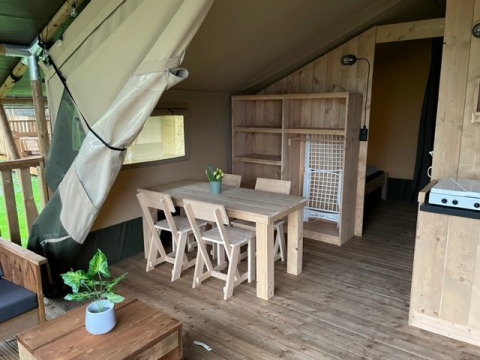 Interior of a safari tent with wooden furniture and sanitary facilities at Campsite de Zeven Heuveltjes, Netherlands.
