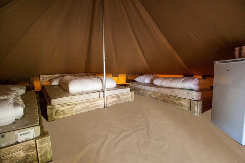 Interior of Glamp tent «GT» at Holiday Park BreeBronne in the Netherlands, showing beds and a fridge.