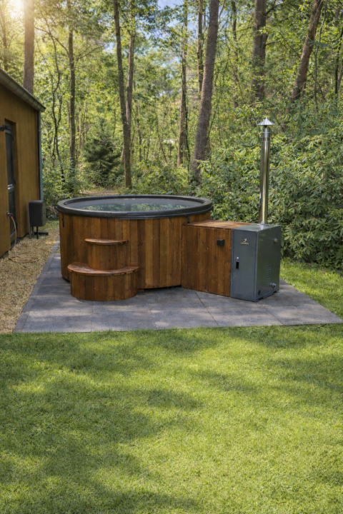 Outdoor hot tub at Zandborg Lodge in Holiday park De Wiltzangh, Netherlands, set in a serene forest setting.
