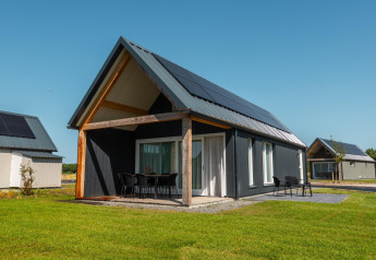 Udendørs billede af Duinlodge 6 med moderne sort facade, terrasse og solpaneler på taget.