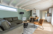 Modernes Wohnzimmer in Duinlodge 6 bei EuroParcs Cadzand-Bad, Niederlande, mit grüner Couch.