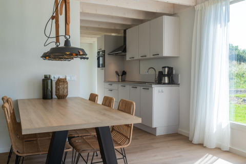 Moderne spise- og køkkenområde i Duinlodge 6, EuroParcs Cadzand-Bad, Holland, med naturligt lys.