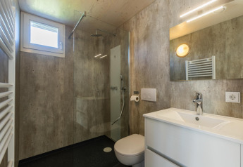Salle de bain moderne avec douche, WC et lavabo à Duinlodge 6, EuroParcs Cadzand-Bad aux Pays-Bas.