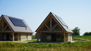 Due moderni lodge in legno con pannelli solari sui tetti presso Duinvilla 10, immersi nel verde.
