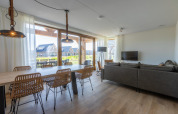 Modernes Wohnzimmer und Essbereich in Duinvilla 8, EuroParcs Cadzand-Bad, mit großen Fenstern und Ausblick.