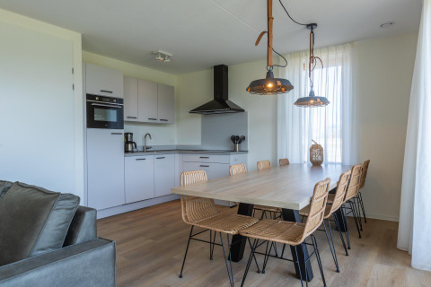 Cucina e sala da pranzo moderne in Duinvilla 8 a EuroParcs Cadzand-Bad, Paesi Bassi, con arredi chiari.