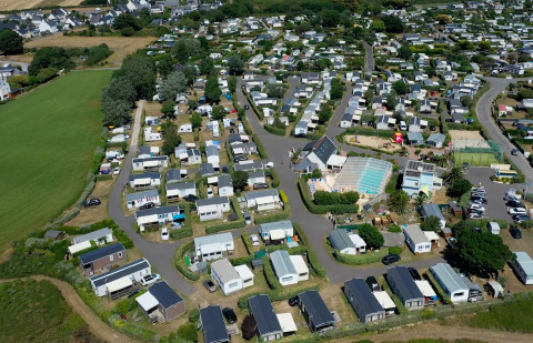 Aerial view of Flower Camping La Pointe du Talud holiday park with cabins and pool in Brittany, France.