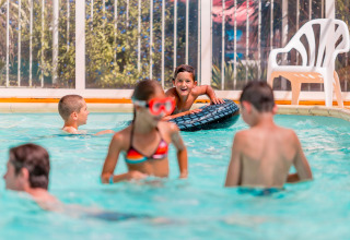 Des enfants jouent et nagent dans une piscine intérieure au Flower Camping La Pointe du Talud en Bretagne, France.