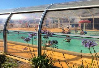 Indendørs swimmingpool med legende børn og voksne på Flower Camping La Pointe du Talud, Bretagne, Frankrig.