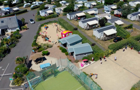 Vue aérienne de Flower Camping La Pointe du Talud en Bretagne avec mobil-homes, aire de jeux et terrain de sport.