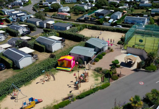 Luftaufnahme vom Flower Camping La Pointe du Talud in der Bretagne mit Spielplatz und Mobilheimen