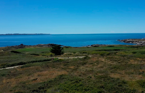 Coastal scenery at Flower Camping La Pointe du Talud, Brittany, France, with clear blue skies and sea.