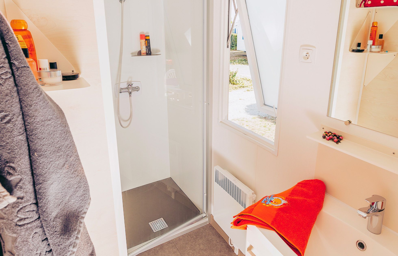 Badkamer met douche, wastafel en spiegel in mobile home Comfort BAHIA bij Flower Camping La Pointe du Talud.