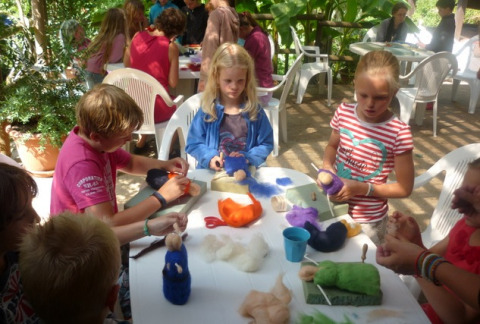 Bambini che fanno lavori creativi all'aperto al campeggio La Grande Véyière in Nuova Aquitania, Francia.