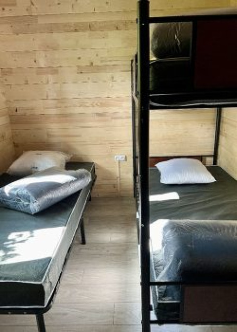 Kamer met twee eenpersoonsbedden en een stapelbed in een chalet op Campsite La Grande Véyière, Frankrijk.